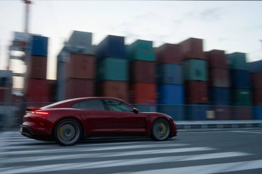 A red Porsche Taycan Turbo S in high speed with motion blur effect, Antalya, Turkey