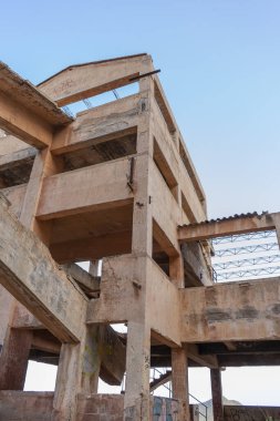 Mavi gökyüzüne karşı terk edilmiş bir binanın dikey görüntüsü..