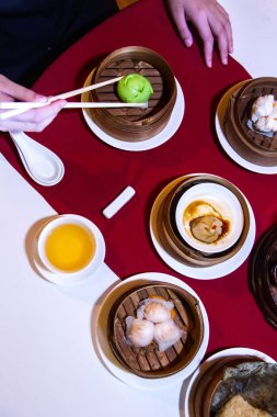 Bir restoranda geleneksel Çin yemekleriyle dolu bir masanın dikey çekimi.