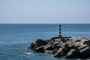 Portekiz, Madeira 'da mavi okyanus arka planında bir deniz fenerinin manzarası