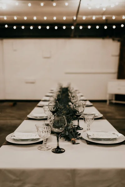 A vertical shot of a wedding table set up under the lights