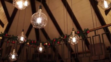 A selective focus shot of light bulbs hanging from the ceiling as decoration for a celebration party