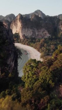 A drone footage of the tropical beach, cliffs, vegetation and boats