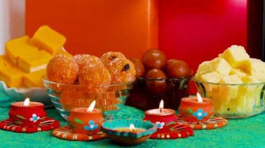 Colorful Diwali oil lamps, Deepavali oil lamps lighted in beautiful formation with bowls full of different Diwali sweets . Decorative Colorful Diya