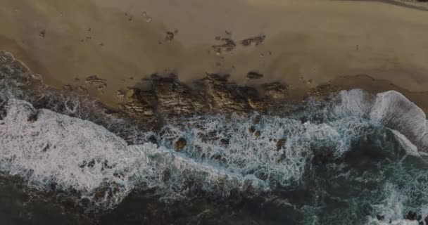 波のある海の近くのビーチ ポルトガルのミラマール ヴィラ ノヴァ ガイアの上からの空中のトップビュー 夕暮れ時の大きな岩 — ストック動画