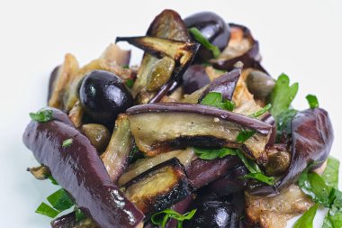 closeup on fried eggplant with capers and  black olives  ,mediterranean italian appetizer, white background