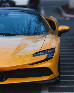 A front view of a luxurious yellow supercar parked outside