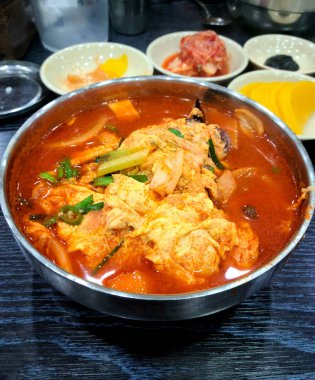 A vertical closeup shot of a Korean soup on the table