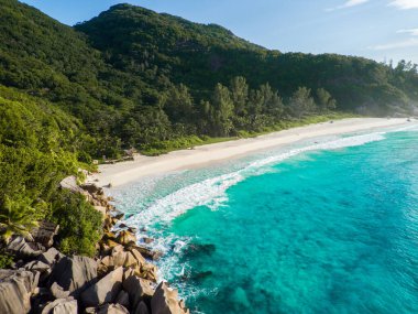 A scenic view of blue ocean waves hitting the beach in sunny weather