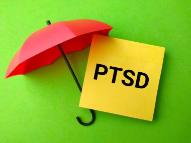 A top view of a red umbrella and a sticky note with the word PTSD