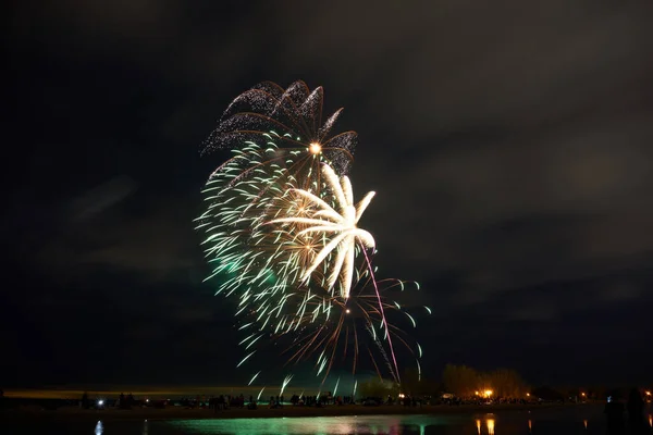 A view of fireworks over buildings in night