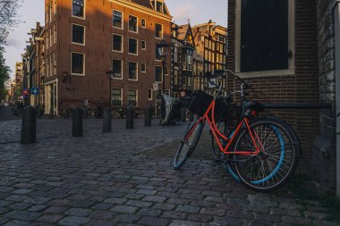 A couple of bicycles leaned on an old brick building in the city of Amsterdam, Netherlands