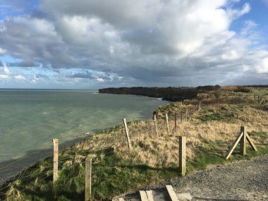 A fence with barbed wires on a shore of a beautiful calm lake