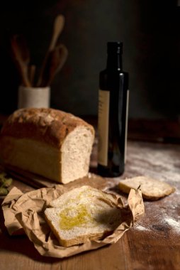 A vertical closeup of homemade sourdough bread with olive oil.