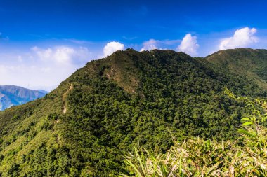 Arka planda bulutlu gökyüzü olan güzel bir dağ manzarası.