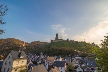 A beautiful cityscape of Monreal with the ruin castle on a green hill in Germany