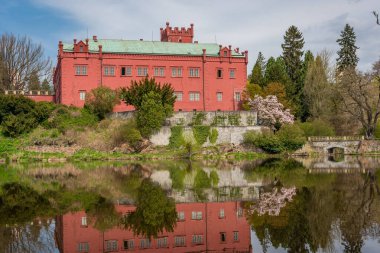 Neo gothic castle in Klasterec nad Ohri reflected in the Ohre river on a sunny spring day