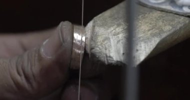 Jakarta, Indonesia-June 19,2022: a traditional goldsmith forms a ring with a hone