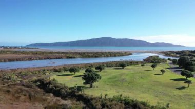 the Waikanae river mouth as it enters the tasman sea. Kapiti Island on the horizon