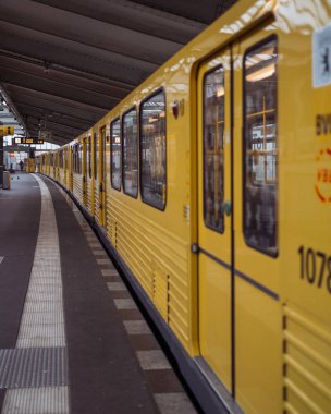 A perspective shot of a yellow train parked at the gate.