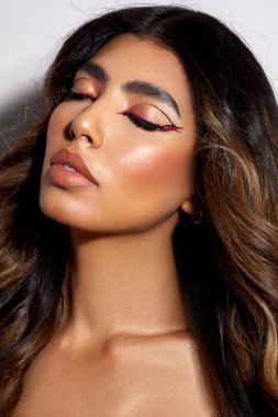 A vertical portrait of a beautiful Australian female model with closed eyes and makeup on her