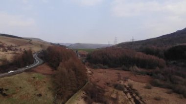 An aerial view of vehicles on the highway cutting through the Peak district in United Kingdom