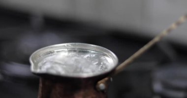 The boiling water in a pot down on a household gas