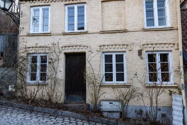 Pek çok penceresi olan, eski, tuğladan bir evin yakın çekimi.