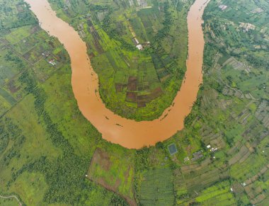 the top view of a river which is in half circle and surrounded with many fields