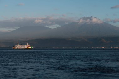 The Ferry Boat Crossing the Bali Strait on a sunny morning with Mount Ijen and Mount Raung