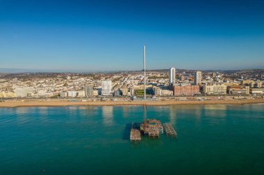 An aerial view past the ruins of the west pier towards the seashore at Brighton, UK