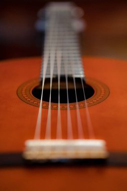 A vertical selective focus shot of the sound hole of an acoustic guitar