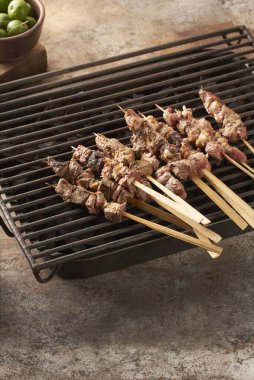 A vertical closeup shot of goat satays ready to be roasted