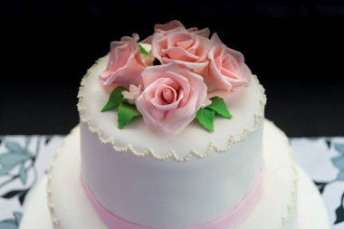 A two-floor floral cake on a table in a wedding room