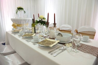 Düğün masasının bir fotoğrafı. Etkinlik salonunda zarif bir dekor var.