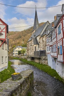 A lake separating buildings in Monreal, Eifel region, Germany
