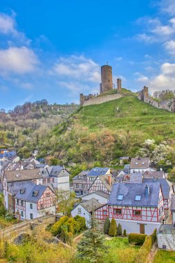A vertical shot of the Lowenburg and Philippsburg castles on the hill in a little town called Monreal in Eifel, Germany