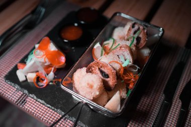 Yanında küçük bir salata porsiyonu olan metal bir kasede tavuk külçeleri.