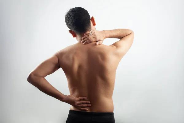 Pain in the spine, a man with backache, injury in the human back and neck in white background