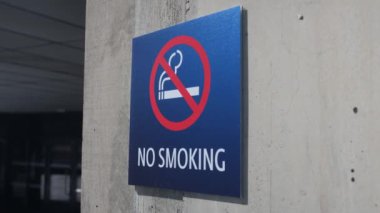 A closeup of a blue No Smoking sign on the wall