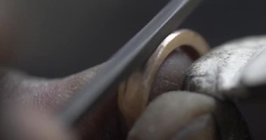 Jakarta, Indonesia-June 19,2022: a traditional goldsmith forms a ring with a hone