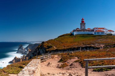 A scenic view of a lighthouse at Cabo de Roca, Portugal in blue sky background