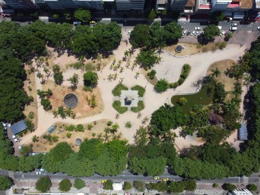 Yeşil ağaçlar ve bitkilerle çevrili bir parkın insansız hava aracı görüntüsü.