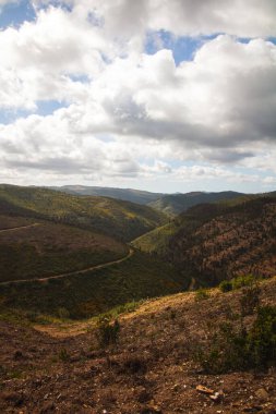 Bulutlu bir gökyüzüne karşı büyüleyici bir manzara.