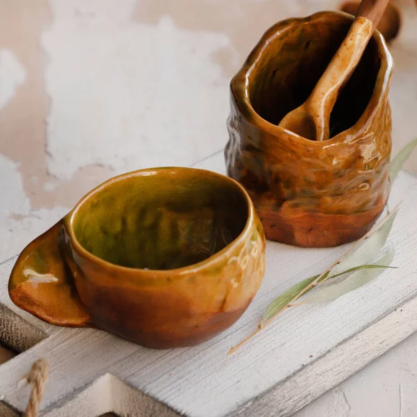 Closeup Shot Odd Shaped Ceramic Mugs Spoon Wooden Surface — стоковое фото