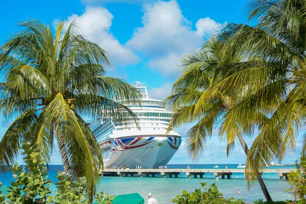 The P&O Azura cruise ship approaching the pier in Grand Turk Island with palm trees in the foreground