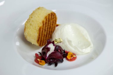 white plate with styled sweet sponge cake fig and ice cream gold leaves and flowers