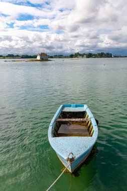 The house of Saint-Cado in Brittany, on the Etel river, with a blue row boat