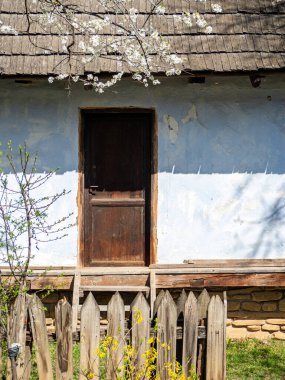 A vertical shot of a wooden door of a house in sunny weather