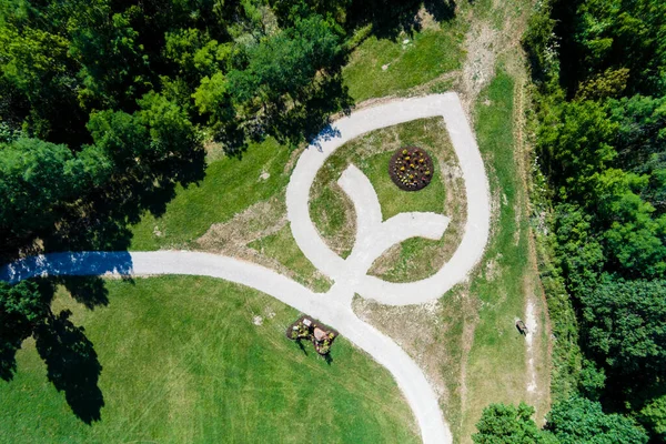 The bird\'s eye view of the green park with a white pattern on the lawn.